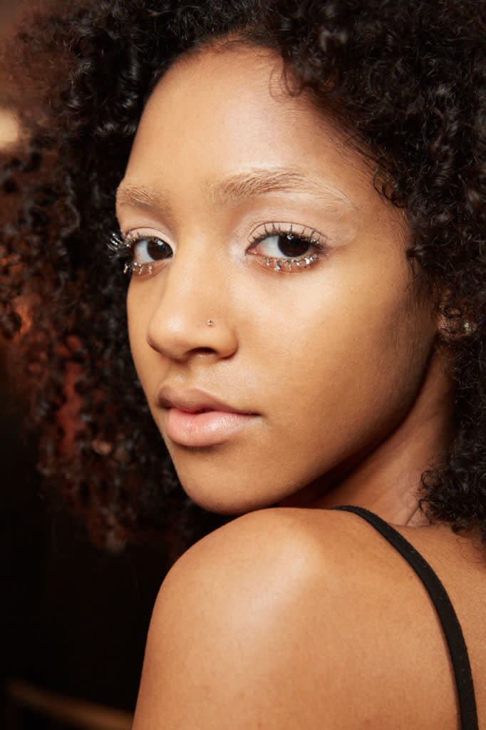 A model smizes with loads of mascara and glitter backstage at LRS New York. (Photo: Maybelline)