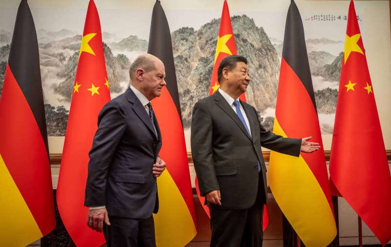 Chinese President Xi Jinping (R) welcomes German Chancellor Olaf Scholz to the State Guest House.  Michael Kappeler/dpa