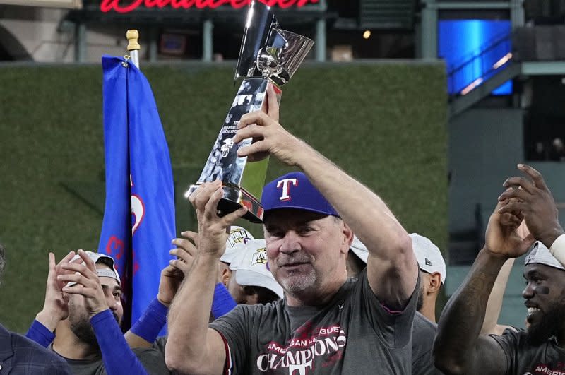 Texas Rangers manager Bruce Bochy holds the trophy after beating the Houston Astros in Game 7 of the American League Championship Series on Monday in Houston. Photo by Kevin M. Cox/UPI