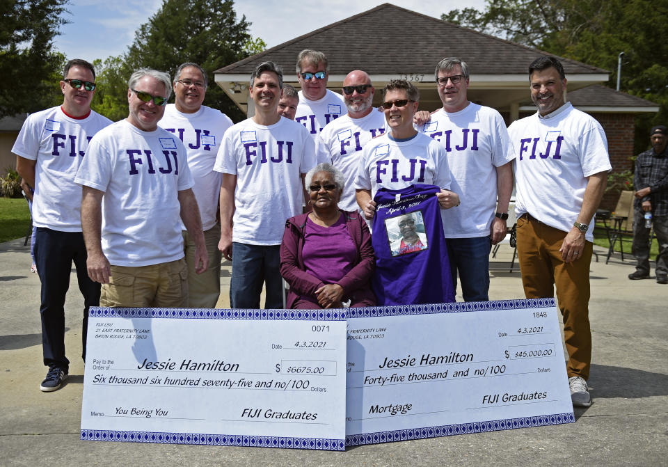 Jessie Hamilton, seated, is surrounded by LSU FIJI graduates as they gathered to surprise their former house kitchen staff member, Saturday, April 3, 2021, and celebrate "Jessie Hamilton Day" in Baker, La. (Hilary Scheinuk/The Advocate via AP)