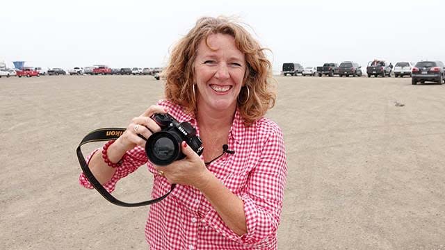 Photographer Charlotte "Ginger" DiNunzio in Morro Bay, California, against a white sky