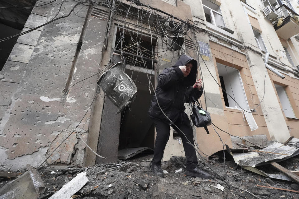 Una mujer sale de un edificio residencial que fue impactado por un cohete ruso, el domingo 5 de febrero de 2023, en la ciudad de Járkiv, Ucrania. (AP Foto/Andrii Marienko)