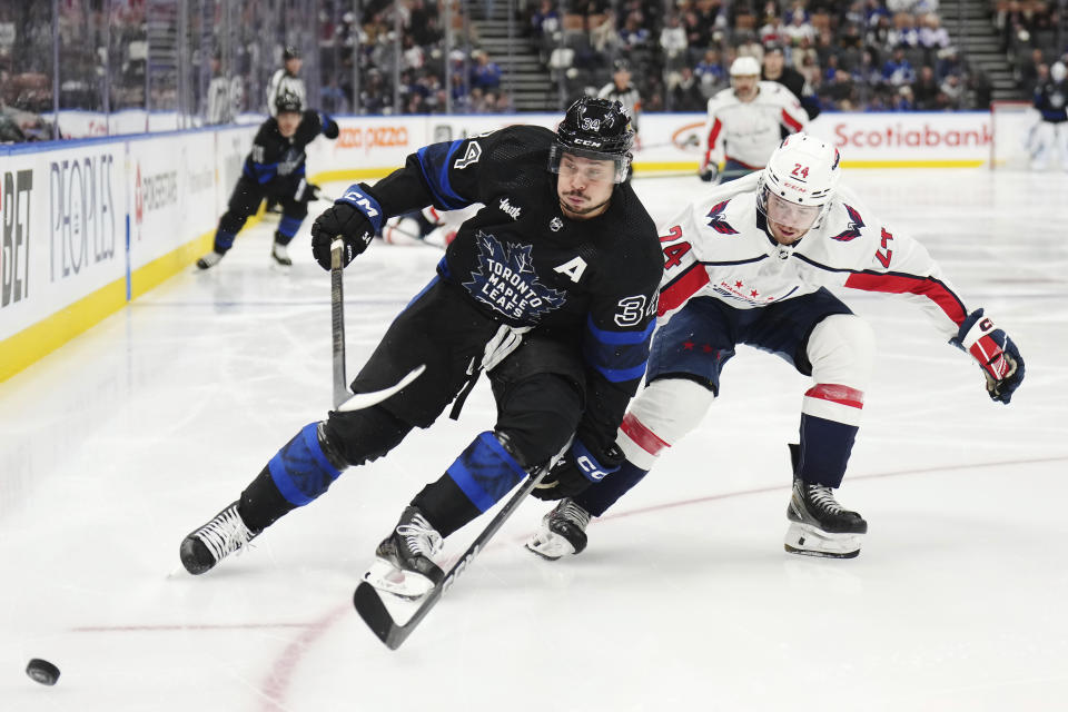 Toronto Maple Leafs forward Auston Matthews (34) and Washington Capitals forward Connor McMichael (24) race for the puck during the second period of an NHL hockey game Thursday, March 28, 2024, in Toronto. (Nathan Denette/The Canadian Press via AP)