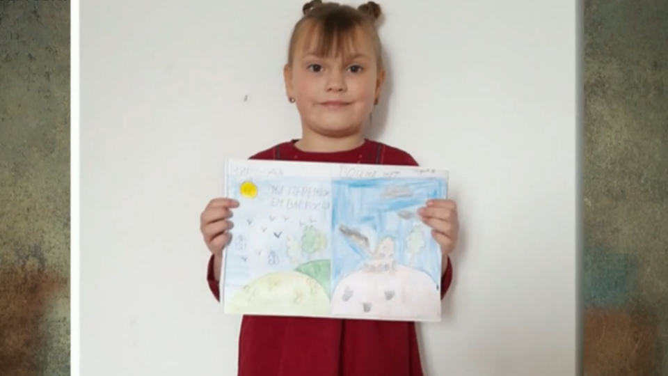 A child displays her artwork depicting the war in Ukraine. / Credit: CBS News