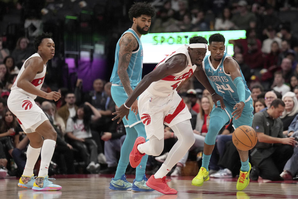 Toronto Raptors forward Pascal Siakam (43) and Charlotte Hornets forward Brandon Miller (24) vie for a loose ball during the second half of an NBA basketball game in Toronto, Monday, Dec. 18, 2023. (Nathan Denette/The Canadian Press via AP)