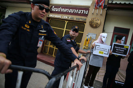 Prison wardens stand guard as demonstrators from Amnesty International hold placards outside the Bang Kwang Central Prison to protest against the death penalty in Bangkok, Thailand, June 19, 2018. REUTERS/Athit Perawongmetha