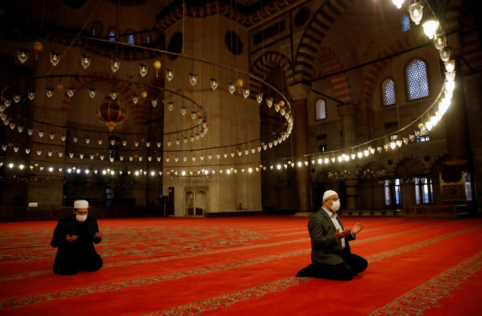 Staff at Suleymaniye Mosque perform a morning prayer behind closed doors during the first day of Eid and the second day of a four-day curfew, amid the coronavirus disease (COVID-19) outbreak, in Istanbul, Turkey May 24, 2020. REUTERS/Umit Bektas TPX IMAGES OF THE DAY