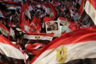 Supporters of Egypt's army chief General Abdel Fattah al-Sisi hold a poster of Sisi in Tahrir square in Cairo, on the third anniversary of Egypt's uprising, January 25, 2014. Nine people were killed during anti-government marches on Saturday while thousands rallied in support of the army-led authorities, underlining Egypt's volatile political fissures three years after the fall of autocrat President Hosni Mubarak. Security forces lobbed teargas and some fired automatic weapons in the air to try to prevent demonstrators opposed to the government reaching Tahrir Square, the symbolic heart of the 2011 uprising that toppled the former air force commander. (REUTERS/Mohamed Abd El Ghany)