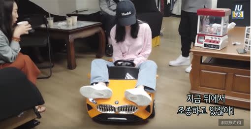 IU開心地在休息室玩粉絲們送給她的玩具車。（圖／翻攝自YouTube）