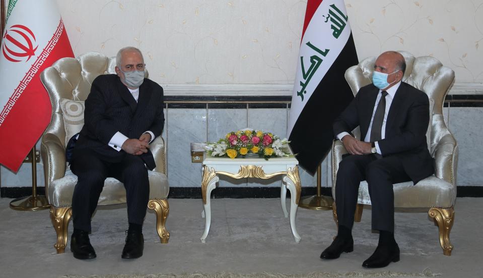 Iraqi Foreign Minister Fouad Hussein, right, meets with visiting Iranian counterpart Mohammad Javad Zarif in Baghdad, Iraq, Monday, April 26, 2021. (AP Photo/Khalid Mohammed)