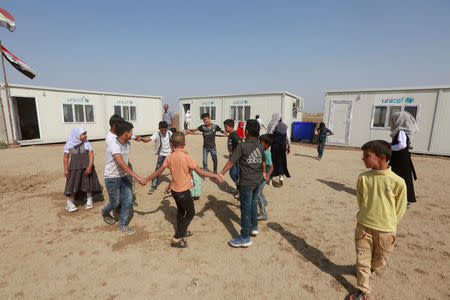 Children of Iraqi Kawliya group (known as Iraqi gypsies) play outside a school in al-Zuhoor village near the southern city of Diwaniya, Iraq April 16, 2018. Picture taken April 16, 2018. REUTERS/Alaa Al-Marjani