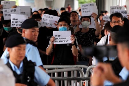 Protesters hold signs following a day of violence over an extradition bill, in Hong Kong