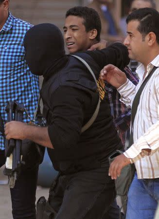 Police detain a youth supporter of the Muslim Brotherhood and ousted Egyptian President Mohamed Mursi during clashes in the Cairo suburb of Matariya November 28, 2014. REUTERS/Mohamed Abd El Ghany