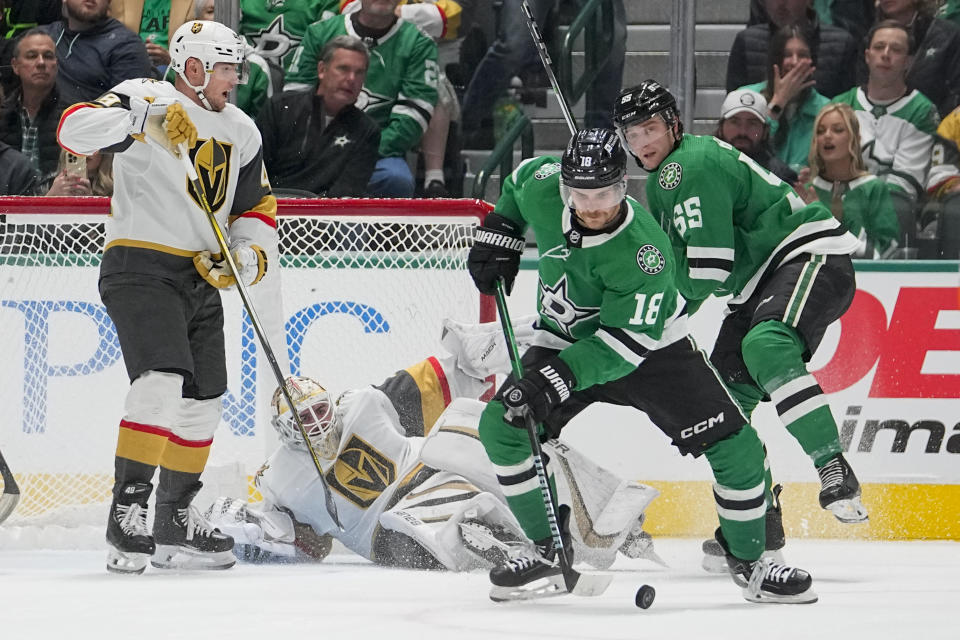 Vegas Golden Knights goaltender Logan Thompson, bottom, falls to the ice as Dallas Stars center Sam Steel (18) controls the puck during the second period of an NHL hockey game, Saturday, Dec. 9, 2023, in Dallas. (AP Photo/Julio Cortez)