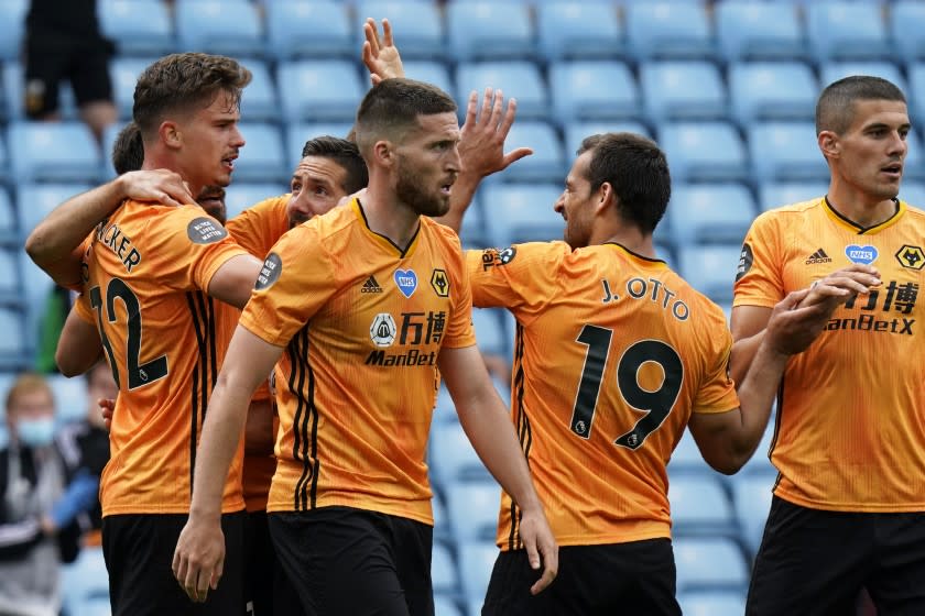 Wolverhampton Wanderers' Leander Dendoncker, left, celebrates after scoring the opening goal during the English Premier League soccer match between Aston Villa and Wolverhampton Wanderers at Villa Park in Birmingham, England, Saturday, June 27, 2020.