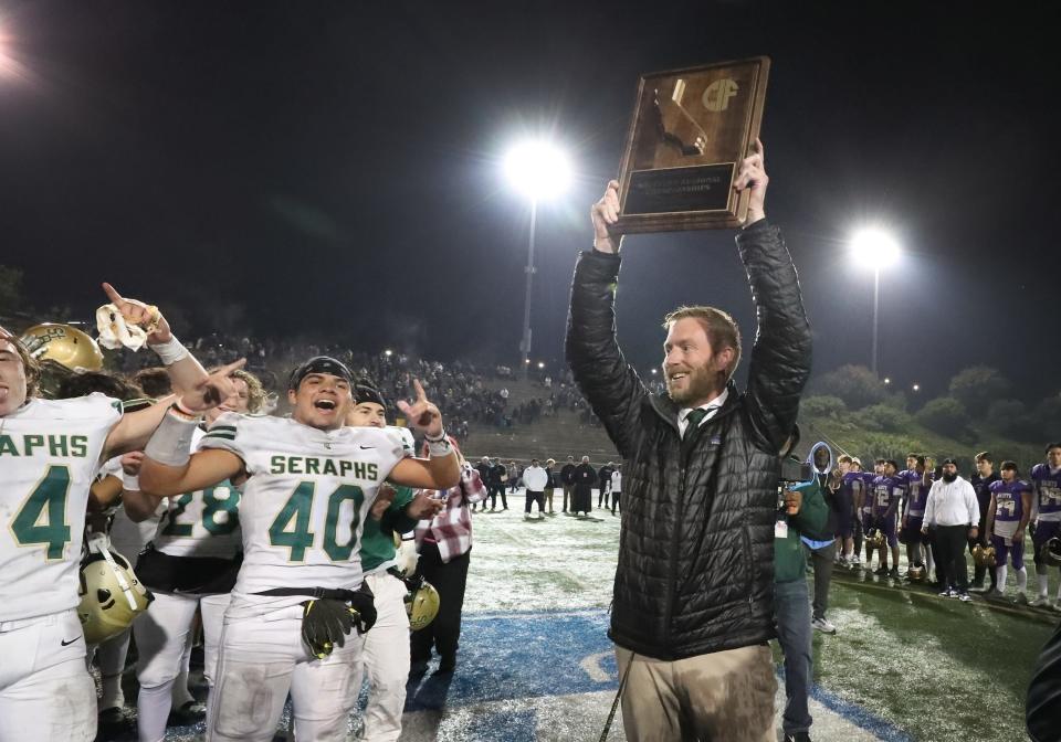 St. Bonaventure head coach Joey Goyeneche holds up the championship plaque after the Seraphs defeated St. Augustine 21-20 in the CIF-State Division 1-A regional final in San Diego on Dec. 2.