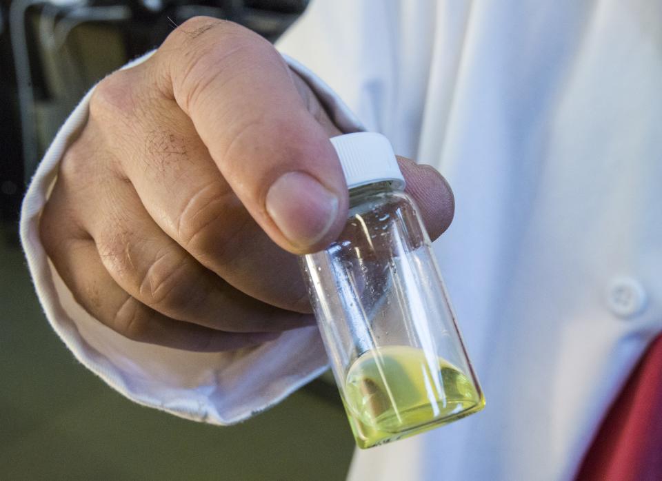 NREL scientist David Moore holds a container holding a perovskite ink formulation which can be painted onto a surface to create a solar cell.