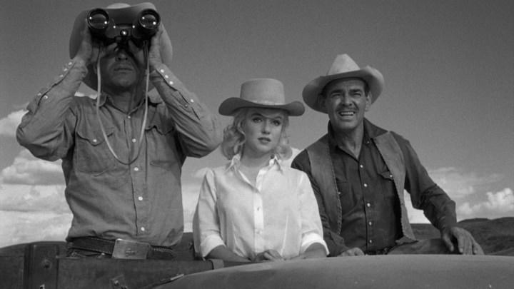 Montgomery Clift, Marilyn Monroe, and Clark Gable standing next to each other in The Misfits