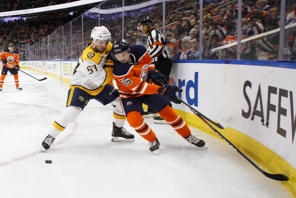 Nashville Predators' Dante Fabbro (57) and Edmonton Oilers' Kailer Yamamoto (56) battle for the puck during second period NHL hockey action in Edmonton, Alberta, Tuesday, Jan. 14, 2019. (Jason Franson/The Canadian Press via AP)