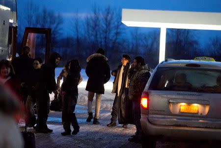 FILE PHOTO: A Northern Taxi driver watches for a fare as people disembark a Greyhound bus in Plattsburgh, New York, U.S., February 16, 2017. REUTERS/Christinne Muschi/File Photo