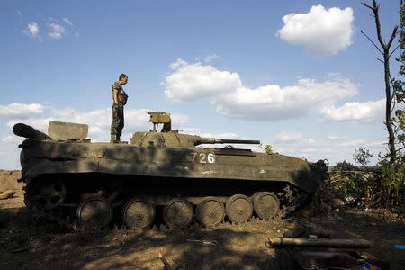 A Ukrainian serviceman stands atop an armoured vehicle at a military camp in Luhansk region August 21, 2014. REUTERS/Valentyn Ogirenko