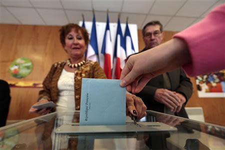 A woman holds her ballot in this illustration photo, before she cast her vote in a polling station during the second round of the French elections in Frejus March 30, 2014. REUTERS/Eric Gaillard