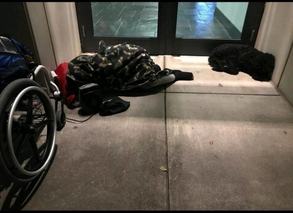 Keith Foster and his dog Tori sleep outside of the Charlotte Convention Center.