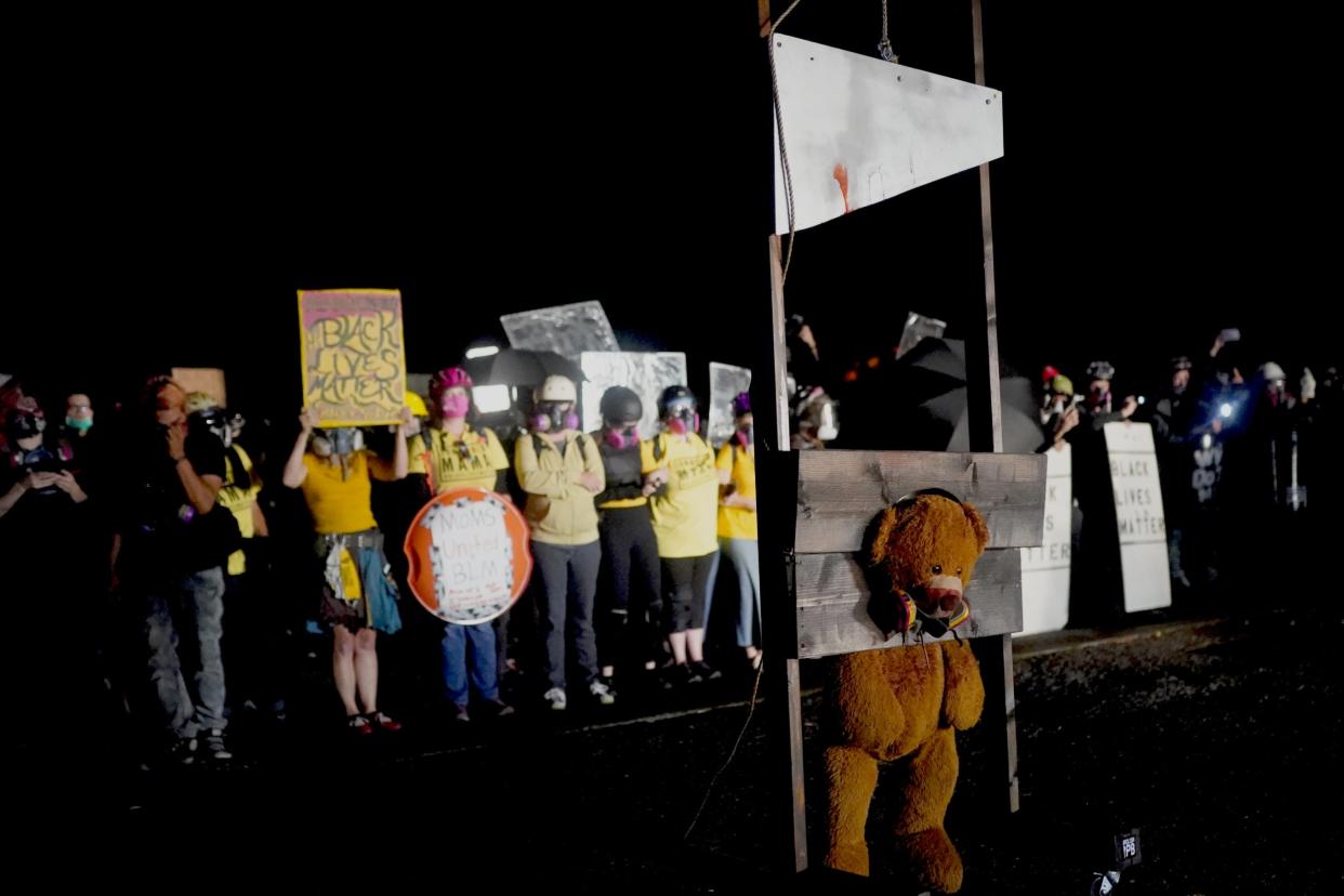 Protestors guillotine a teddy bear wearing a gas mask in Portland (Getty Images)