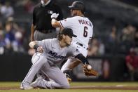 Miami Marlins third baseman Brian Anderson, left, reaches out for a late throw as Arizona Diamondbacks' David Peralta (6) arrives at third base with a triple during the seventh inning of a baseball game Monday, May 10, 2021, in Phoenix. (AP Photo/Ross D. Franklin)