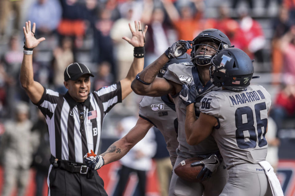 Illinois' Josh Imatorbhebhe, second from right, celebrates with teammates including Donny Navarro (86) after scoring a touchdown in the second half of an NCAA college football game against Wisconsin, Saturday, Oct.19, 2019, in Champaign, Ill. Illinois won 24-21. (AP Photo/Holly Hart)