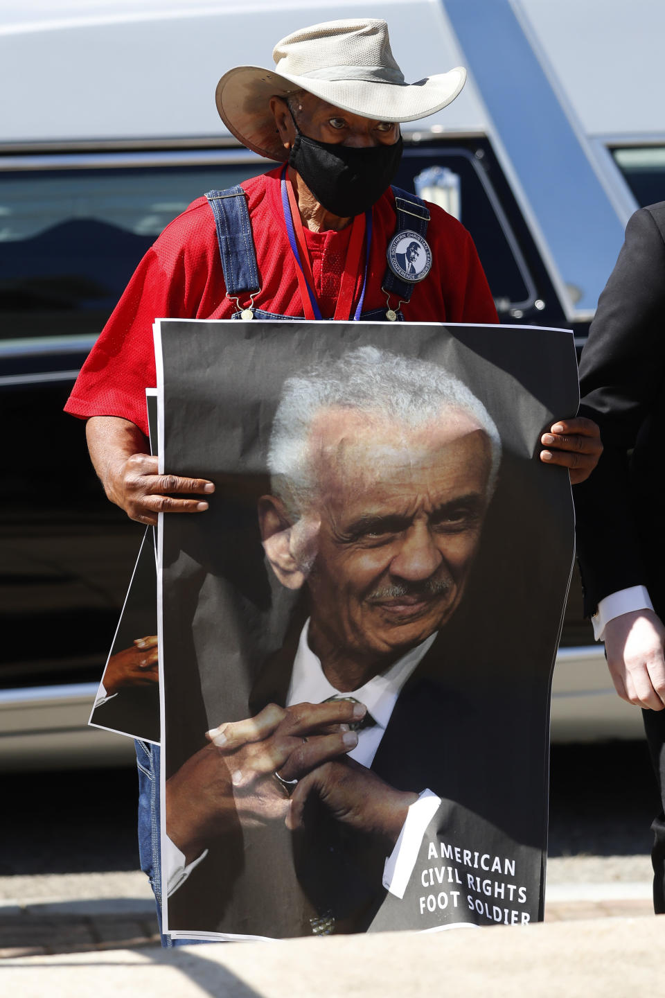 A man holds a poster of Rev. C.T. Vivian funeral service for Vivian Thursday, July 23, 2020, in Atlanta. (AP Photo/John Bazemore)