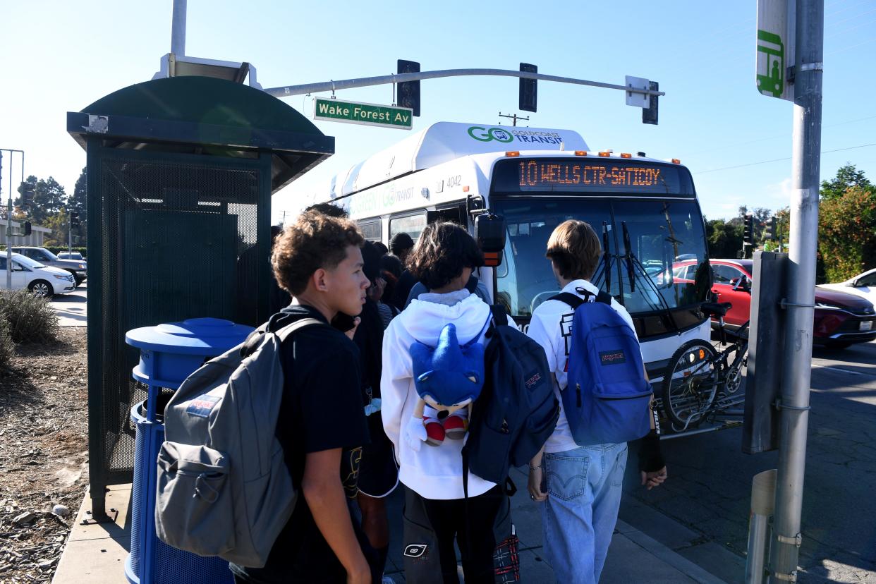 Christian Garcia, left, Ray Ghazi and Caleb Nielsen wait their turns to get on a Gold Coast Transit bus near Buena High School in Ventura on Oct. 20. Under a new pilot program offered by local transit operators, young people can now ride any public bus in Ventura County for free.