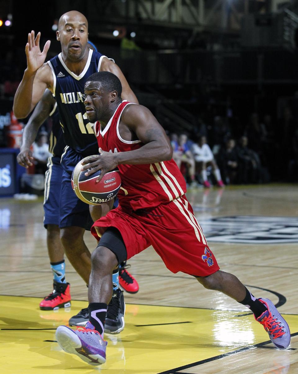 East's Bruce Bowen (12) reaches for West's Kevin Hart, foreground, in the second half as they participate in the NBA All-Star Celebrity basketball game in New Orleans, Friday, Feb. 14, 2014. East won 60-56. (AP Photo/Bill Haber)