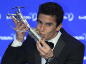 Spain’s MotoGP rider Marc Marquez kisses his Laureus World Breakthrough of the Year trophy as he poses for photos during the Laureus World Sports Awards in Kuala Lumpur, Malaysia, Wednesday, March 26, 2014. (AP Photo/Lai Seng Sin)