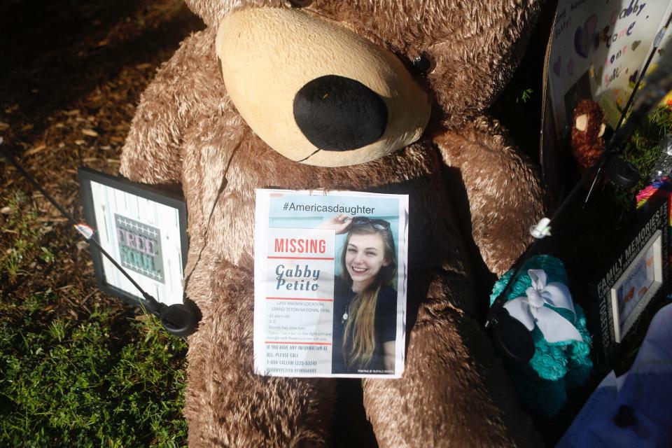 A missing poster of Gabby Petito on top of a teddy bear at a makeshift memorial