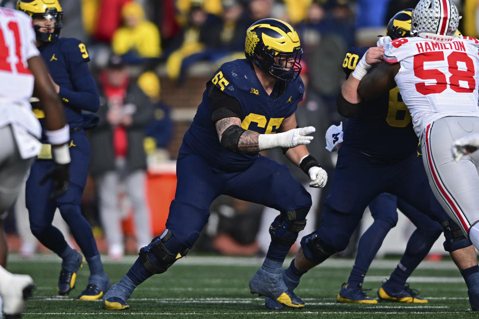 FILE - Michigan offensive lineman Zak Zinter (65) blocks during the first half of an NCAA college football game against Ohio State, Nov. 25, 2023, in Ann Arbor, Mich. Browns draft picks Michael Hall Jr. and Zinter share an interesting past. Fierce rivals in college, they are connected by a play in last year's Ohio State-Michigan game when Hall got blocked into Zinter and accidentally broke his left leg. Now they are teammates in Cleveland. (AP Photo/David Dermer, File)