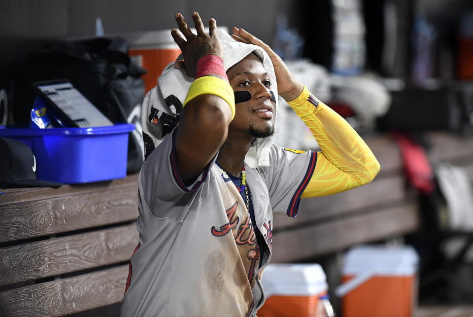Atlanta Braves' Ronald Acuña Jr. sits on the bench after scoring a run during the seventh inning of the team's baseball game against the Miami Marlins, Friday, April 12, 2024, in Miami. (AP Photo/Michael Laughlin)