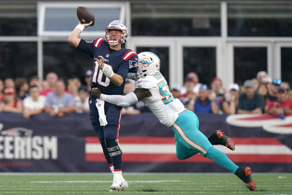 New England Patriots quarterback Mac Jones (10) unloads a pass while pressured by Miami Dolphins outside linebacker Jerome Baker (55) during the second half of an NFL football game, Sunday, Sept. 12, 2021, in Foxborough, Mass. (AP Photo/Steven Senne)