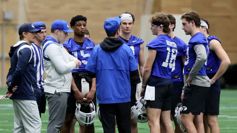 BYU quarterbacks gather with coaching staff at the end of opening day of spring football camp at the BYU Indoor Practice Facility in Provo, on Monday, March 6, 2023.