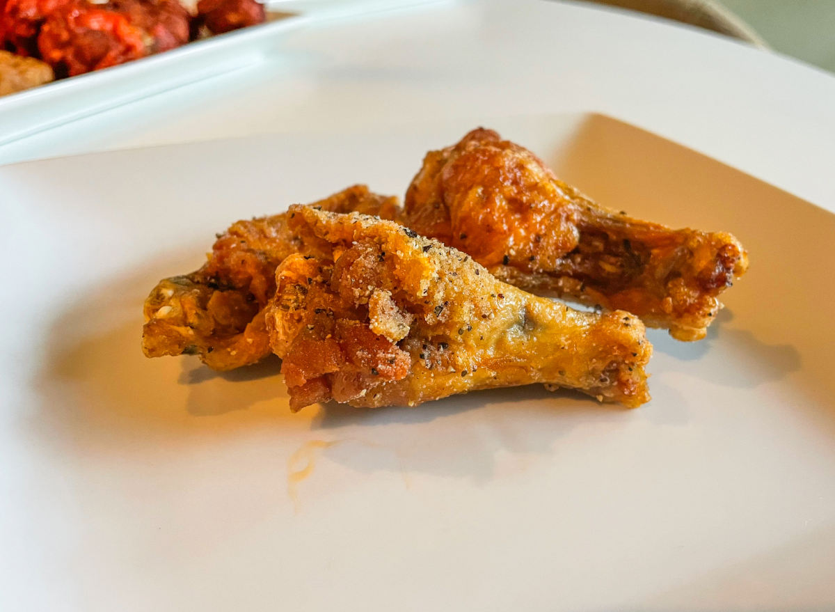 two lemon pepper wings on a plate. 