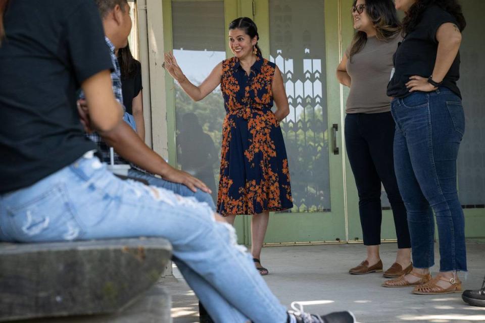 Gabby Trejo, executive director of multi-congregation religious organization Sacramento ACT, talks Friday with members of the group of migrants, left, that were flown to Sacramento from El Paso, Texas, on two flights by a Florida contractor. Hector Amezcua/hamezcua@sacbee.com
