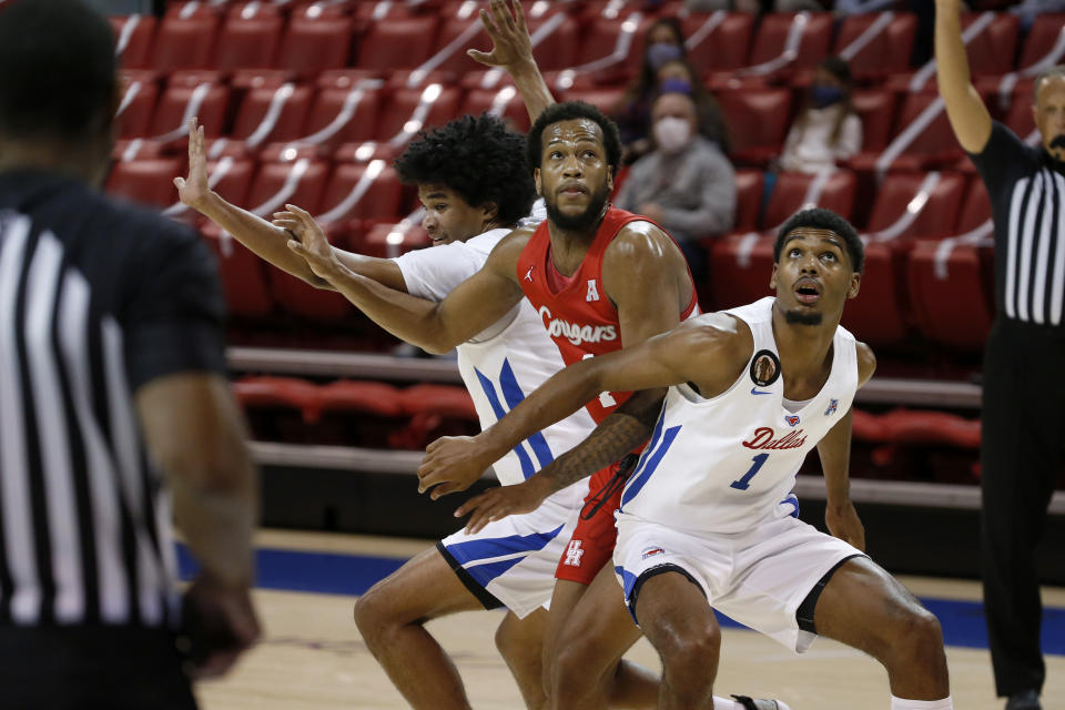 SMU forward Feron Hunt (1) and guard Charles Smith IV, left, fight for position under the basket with Houston forward Justin Gorham, center, during the first half of an NCAA college basketball game in Dallas, Sunday, Jan. 3, 2021. (AP Photo/Roger Steinman)