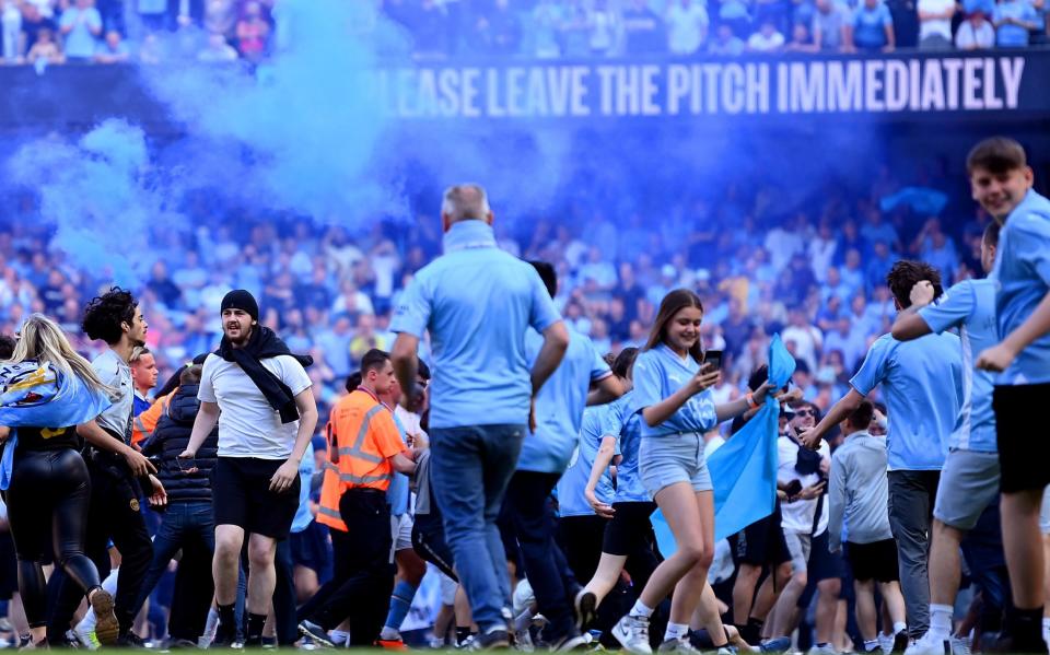 A general view as fans of Manchester City invade the pitch, as the LED Perimeter Board displays the message &quot;Please Leave The Pitch Immediately&quot; - Michael Regan/Getty Images
