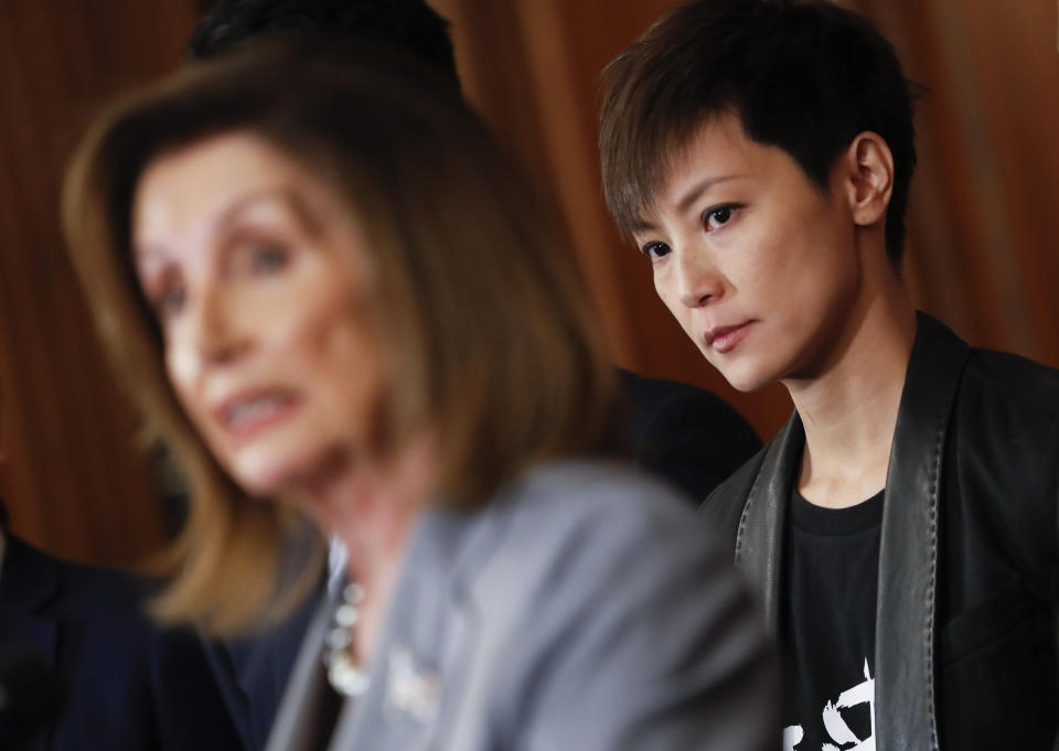 FILE - Hong Kong activist Denise Ho, right, listens to House Speaker Nancy Pelosi of Calif., left, speak during a news conference on human rights in Hong Kong on Capitol Hill in Washington, Wednesday, Sept. 18, 2019. According to the local South China Morning Post newspaper, police arrested Wednesday, Dec. 29, 2021, one current and one former editor at Stand News, as well as four former board members including singer and activist Denise Ho. (AP Photo/Pablo Martinez Monsivais, File)