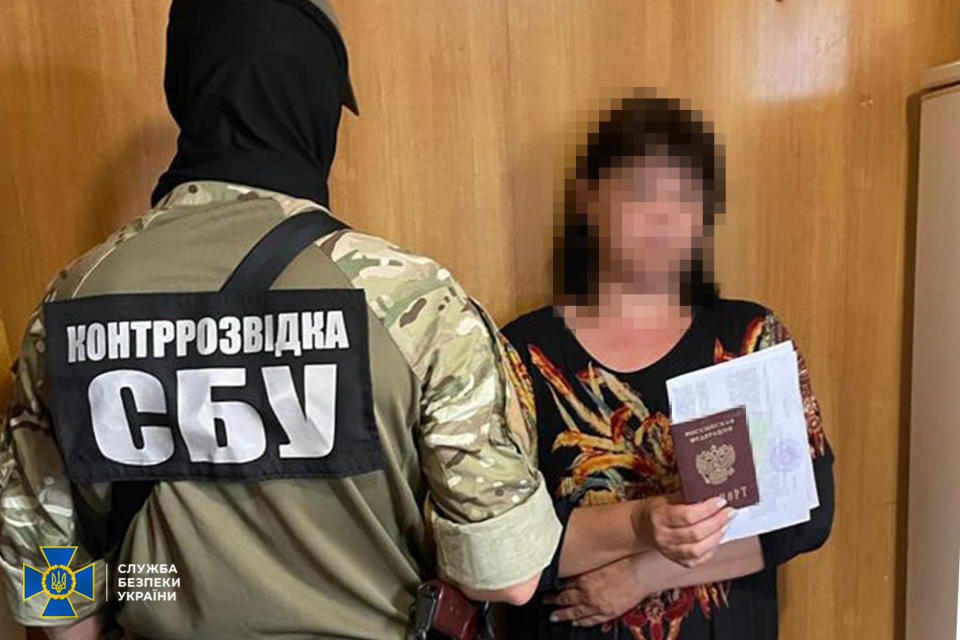 An agent of Ukraine's SBU Counterintelligence agency is seen with a Ukrainian woman from the eastern Pokrovsk district who was arrested as part of an alleged network of Russian informants, according to a statement by the SBU published on August 8, 2023. / Credit: Handout/SBU Counterintelligence