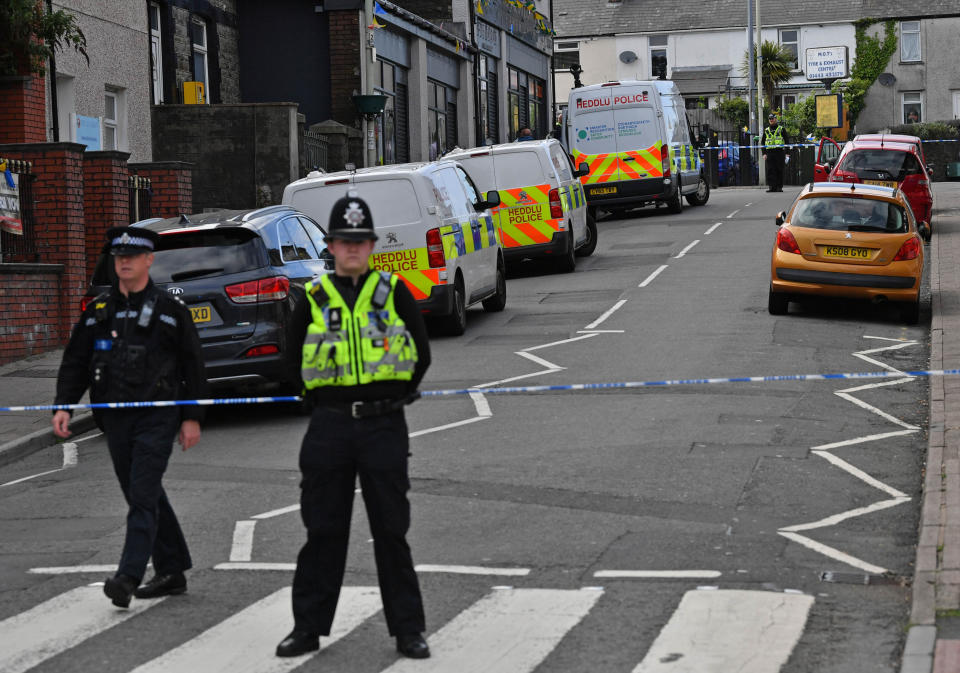 Police at the scene of a reported stabbing in the village of Pen Y Graig in South Wales.