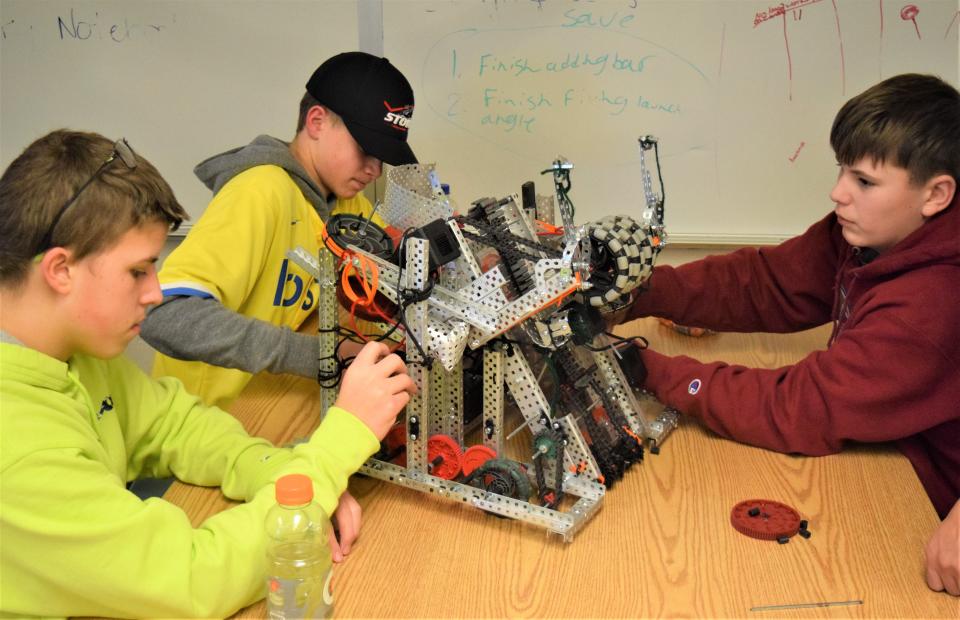 West Holmes freshmen Miles Malach (from left), Collin Badger and Hayden Halverson work on their robotics project.