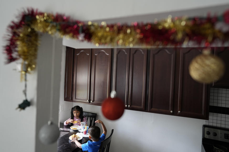 Alexa Llanos, de 7 años, almuerza junto a su hermano Alexis, de 3, en la casa de Lehigh Acres, en Florida, a la que se mudaron en octubre de 2023, cinco años después de haber salido de Venezuela hacia Colombia por amenazas de muerte, el 27 de diciembre de 2023. La de Llanos es una de las primeras familias de migrantes que llegaron a Estados Unidos legalmente bajo un nuevo programa conocido como "Oficinas de Movilidad Segura", que busca agilizar el proceso de refugiados. (AP Foto/Rebecca Blackwell)