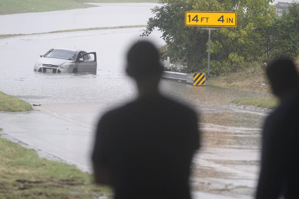 A swamped car sits in flood waters covering a closed highway in Dallas, Monday, Aug. 22, 2022. (AP Photo/LM Otero)