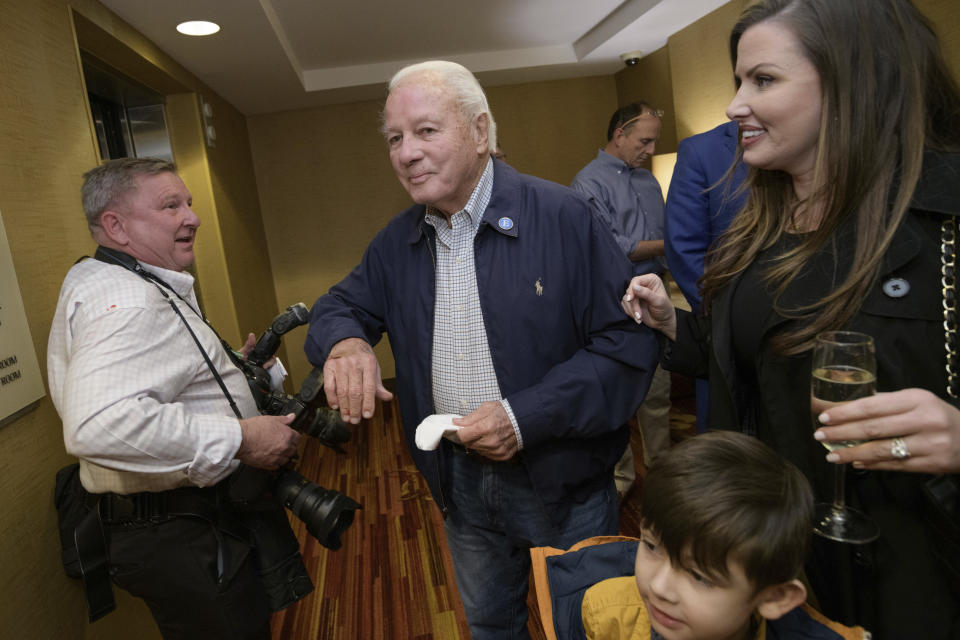 Former Gov. Edwin Edwards greets photographer Travis Spradling, left, as he arrives with his wife Trina Edwards, right, to the election night results for current Louisiana Gov. John Bel Edwards at his election night watch party in Baton Rouge, La., Saturday, Nov. 16, 2019. (AP Photo/Matthew Hinton)